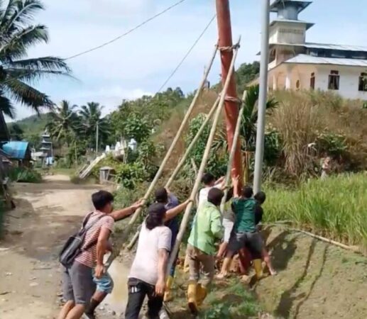 Petugas PLN dibantu masyarakat dalam mendirikan tiang listrik di Desa Hiliwaele II, Kecamatan Botomozoi, Kepulauan Nias, Sumatera Utara.